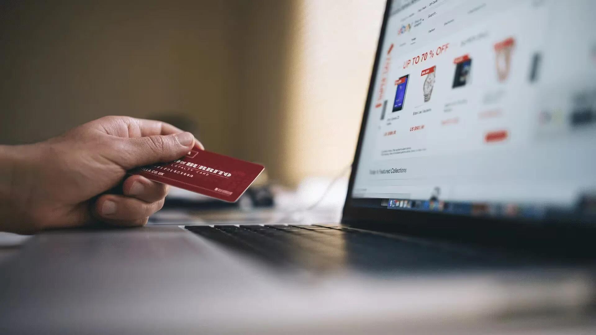 Black and Gray Laptop Computer With Turned-on Screen Beside Person Holding Red Smart Card