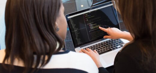 Two Women Looking At Code